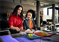 Two women looking at material samples and talking