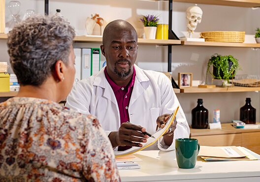 An older patient visits a doctor at his private clinic. 