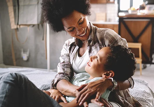 A mother hugs her son at home in South Africa.