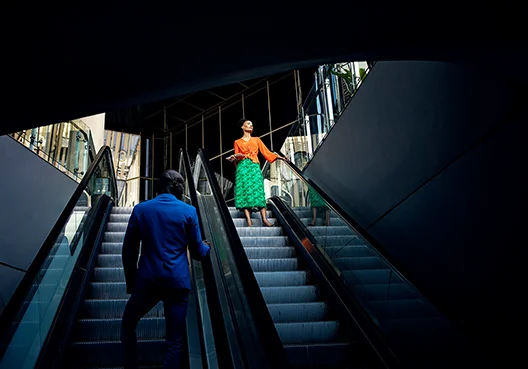 An Old Mutual Corporate Consultant stands on an escalator travelling down. 