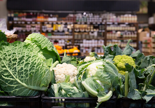 Boxes packed with fresh cauliflower heads ready to be packed into shelves at a supermarket