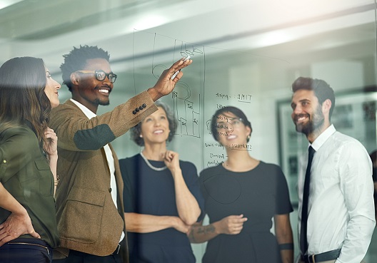colleagues gathering around a drawing board