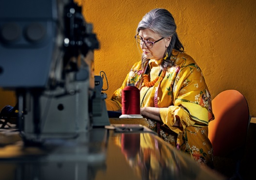 mature woman sitting in front of a sewing machine