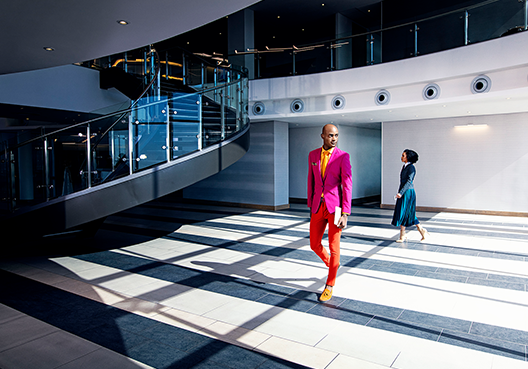 Person in red pants suit walking into a building