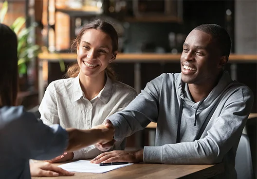 A South African man sitting next to his partner shakes hands and smiles after having his complaint resolved.