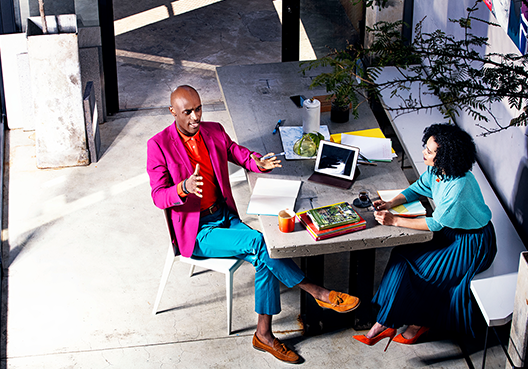 A businessman and businesswoman sitting at a table talking