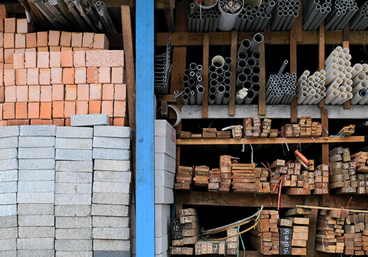 Storage filled with raw materials, such as bricks, concrete blocks, pipes, and wood.