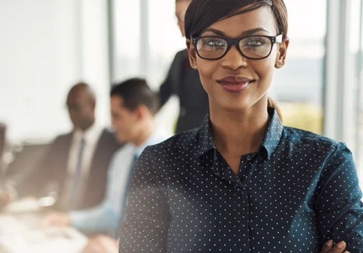 An insurance specialist wearing glasses and a dotted navy blue blouse prepares to meet a client.