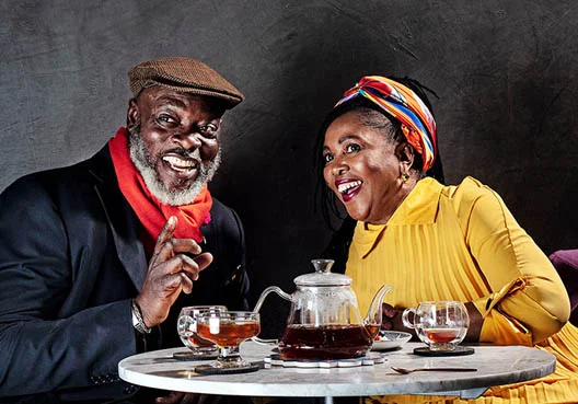 A woman chats to her elderly father about retirement solutions over a cup of tea.