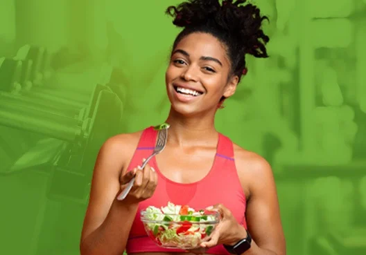 A young lady eating a salad happy about earning bonus points for being healthy and fit from the Rewards Programme.