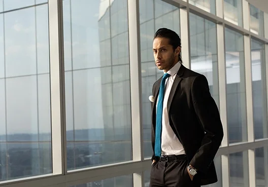 Man in formal wear is standing in an office