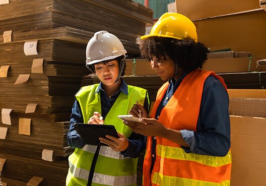 Two female business owners talk about their paper business at their factory. 