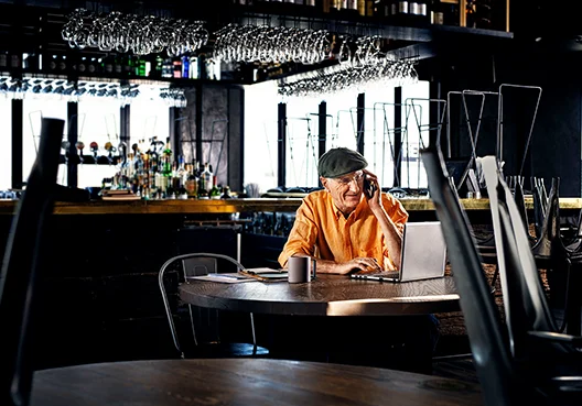 Man looking at his laptop in a coffee shop