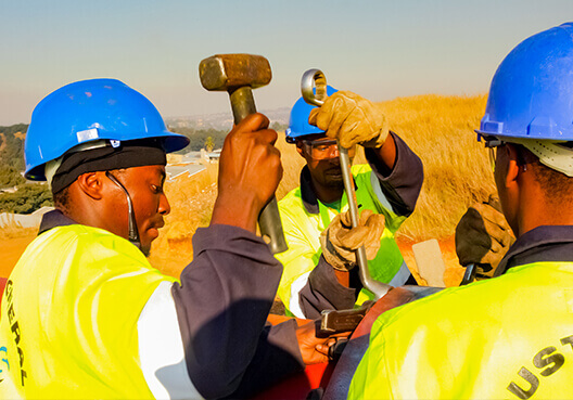 Construction workers wearing safety gear work onsite in South Africa. 