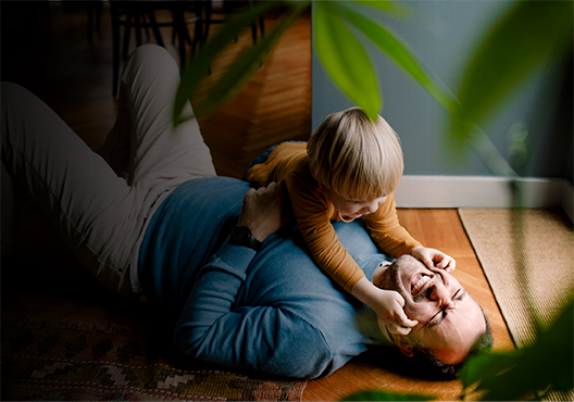 An older tailor measures a garment at his workshop.
