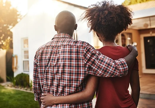 A South African couple with the house they purchased after following financial planning advice from their Financial Adviser.