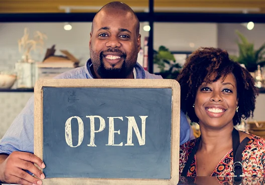 Two business professionals review different insurance quotes for their company.