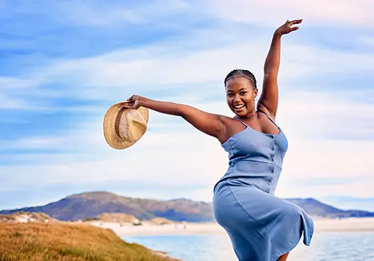 A young black South African lady striking a pose at the beach.