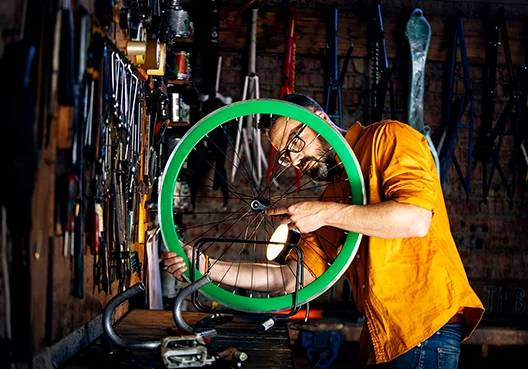 A man not yet ready to draw on his retirement savings works n a wheel at his home workshop.