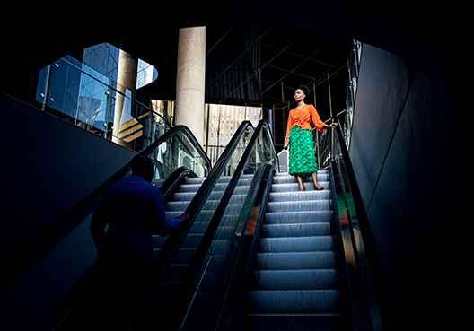 woman walking down an escalator