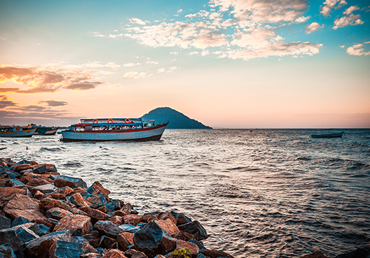 A boat sails on the sea at a popular holiday destination.