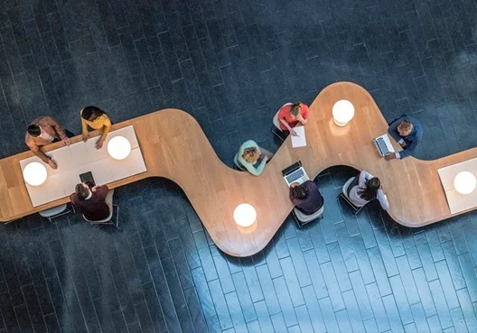 colleagues gathering around a table in office foyer