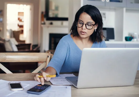 A woman sits at her desk to calculate his monthly income tax.