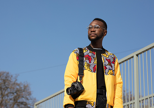 A man in yellow caring a camera